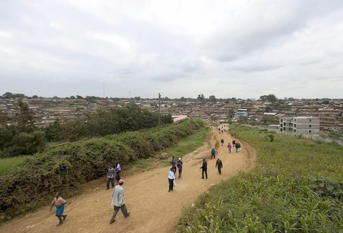 People walk toward the Nairobi slum of Kibera in Kenya in June. In Kibera, most mob attacks are carried out by young men in small vigilante groups who rely on informants.
