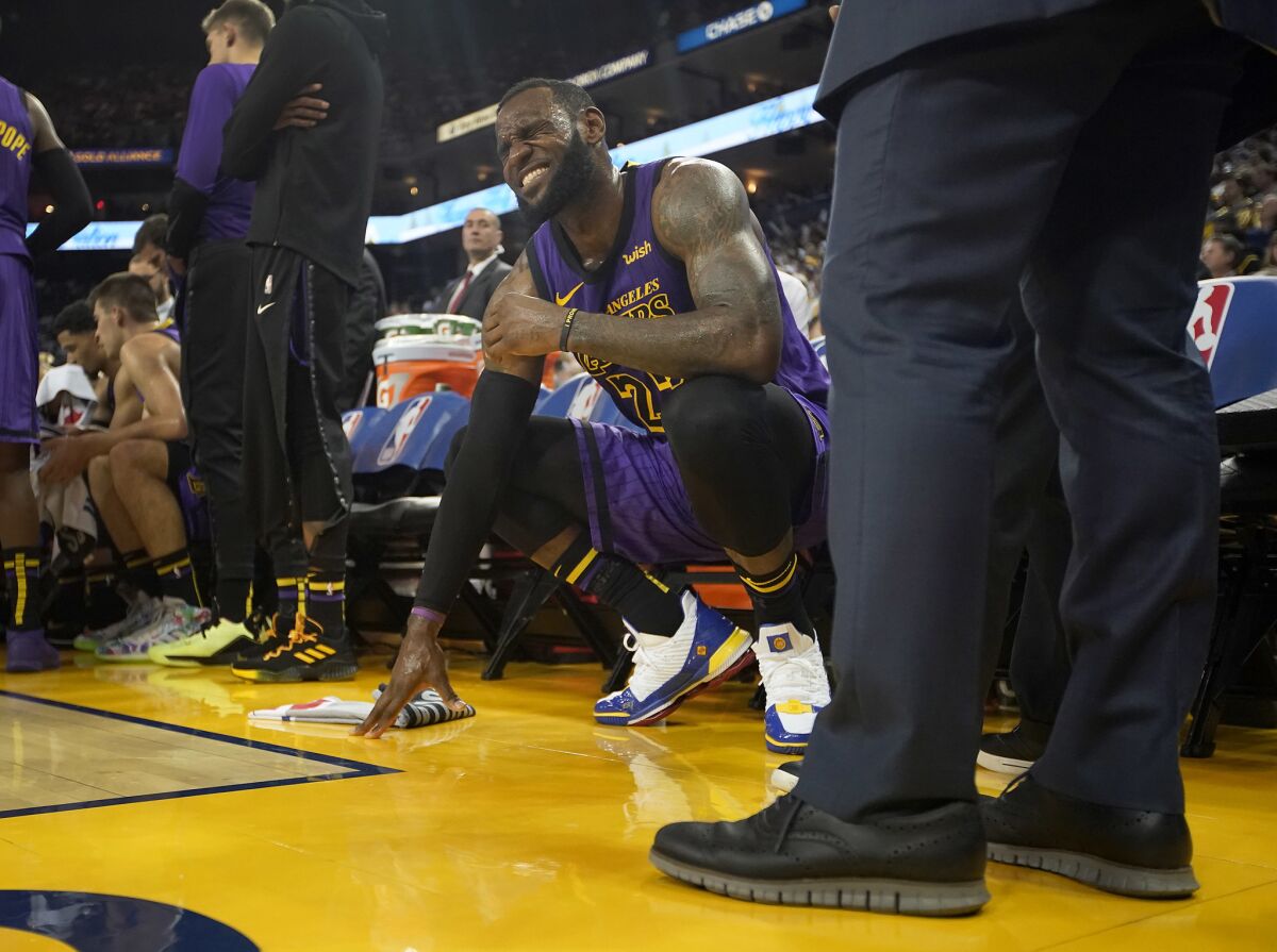 LeBron James, alero de los Lakers de Los Ángeles, hace una mueca tras sufrir un tirón en la ingle izquierda durante el encuentro ante los Warriors de Golden STate, el martes 25 de diciembre de 2018.
