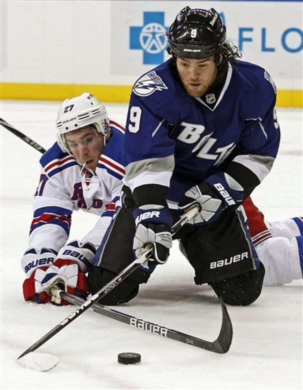 Tampa Bay Lightning's Steve Downie, right, and New York Rangers' Ryan McDonagh battle for a loose puck during the second period of an NHL hockey game, Saturday, Dec. 3, 2011, in Tampa, Fla. (AP Photo/Mike Carlson)