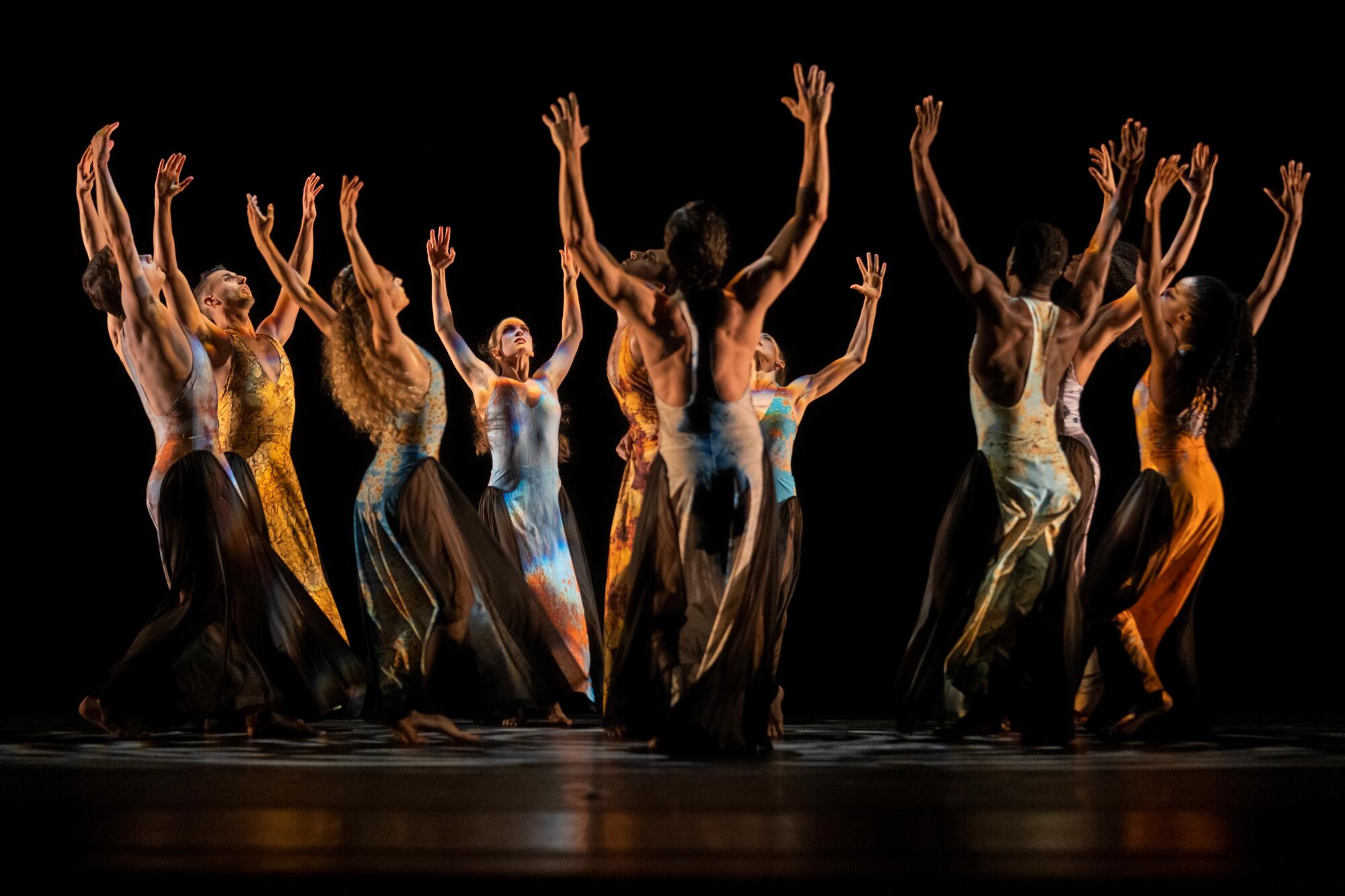 Dancers onstage with their hands up in a circle.