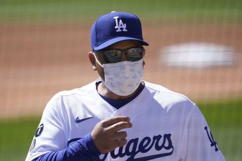 Los Angeles Dodgers manager Dave Roberts talks with some fans prior to a spring training baseball game against the Colorado Rockies Monday, March 1, 2021, in Phoenix. (AP Photo/Ross D. Franklin)