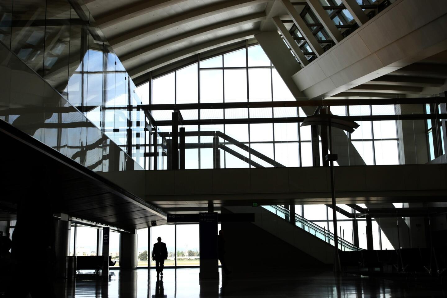 A man makes his way through the new north concourse of the Tom Bradley International Terminal at Los Angeles International Airport. The gates are the first of 18 to be built. Two of the gates, which were unveiled Wednesday, can accommodate the larger new-generation aircraft, such as the Boeing 747-8 Intercontinental and Airbus A-380 super jumbo jets.