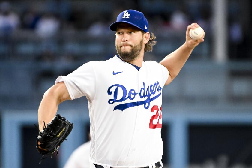 Dodgers starting pitcher Clayton Kershaw scrunches his face and delivers a pitch from the mound