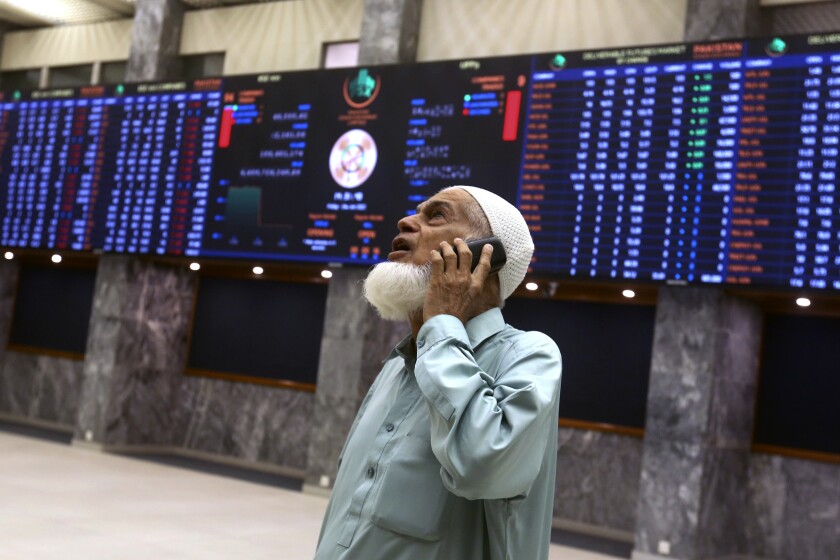 An investor monitors Index on the big screen at at the Pakistan Stock Exchange (PSE), in Karachi, Pakistan, Friday, June 24, 2022. Pakistan's stock market suddenly fell by three percent on Friday, shortly after the government of recently elected Prime Minister Shahbaz Sharif suddenly announced the imposition of additional taxes on the corporate and banking sector in an effort aimed at stabilizing the country's fledgling economy. (AP Photo/Fareed Khan)