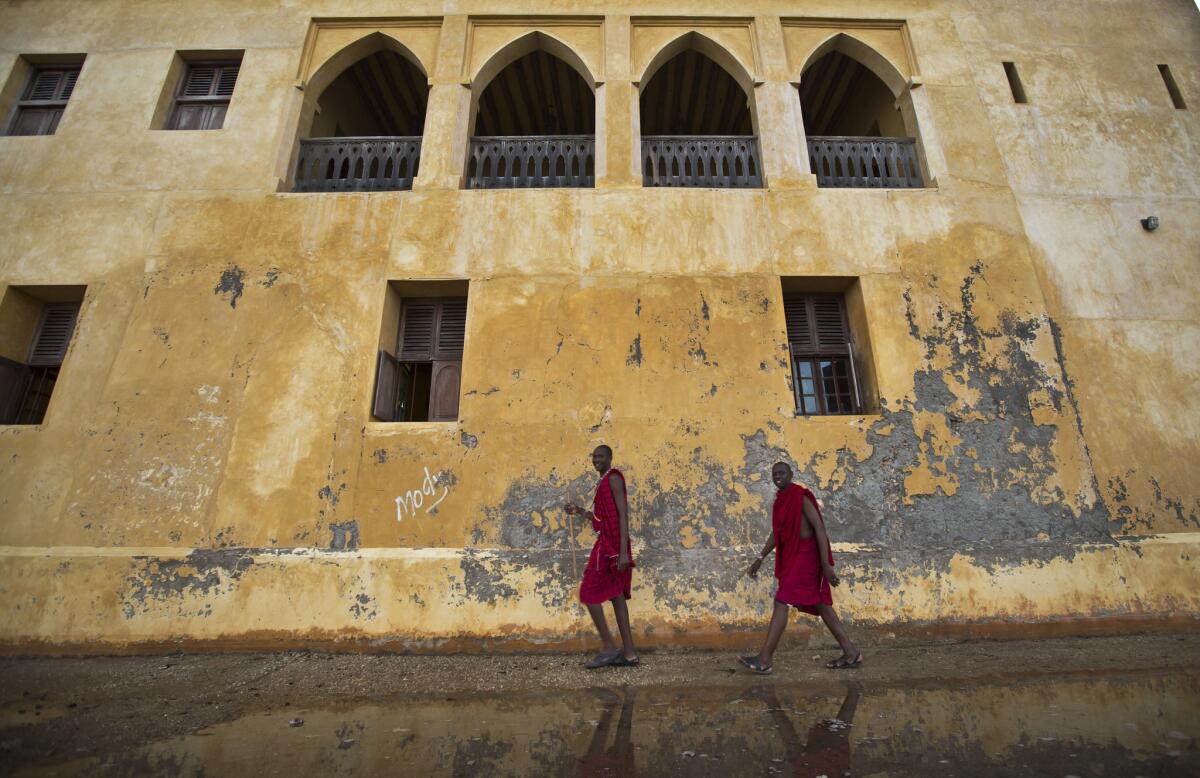 Men dressed in traditional Masai clothing walk next to the ocean on Lamu Island, a popular tourist destination off the north coast of Kenya. Ebola is affecting tourism in parts of Africa thousands of miles away from the outbreak.