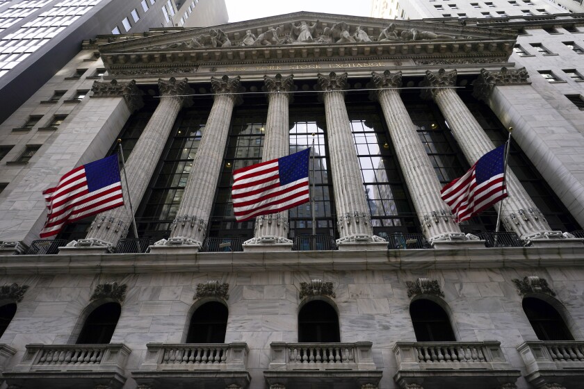 Banderas de Estados Unidos ondean en la fachada de la Bolsa de Valores de Nueva York, el viernes 14 de enero de 2022. (AP Foto/Mary Altaffer)