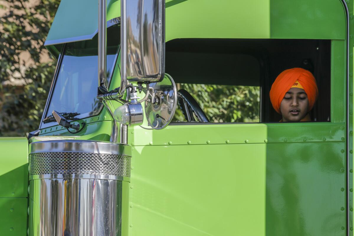 Ekamjit Sandhu sits in his uncle's truck at Nagar Kirtan festivities in Jurupa Valley. (Irfan Khan / Los Angeles Times)