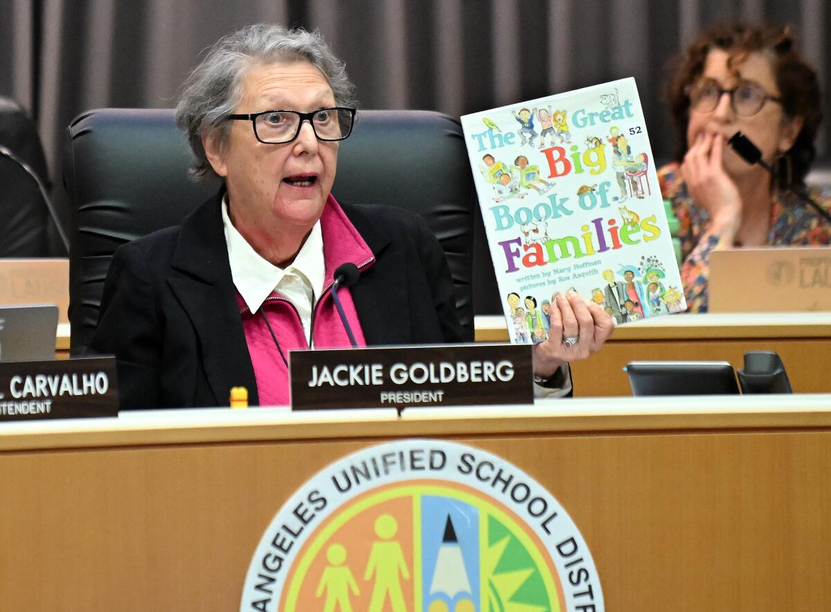 An LAUSD school board member holds up 'The Great Big Book of Famialies' during a public meeting.