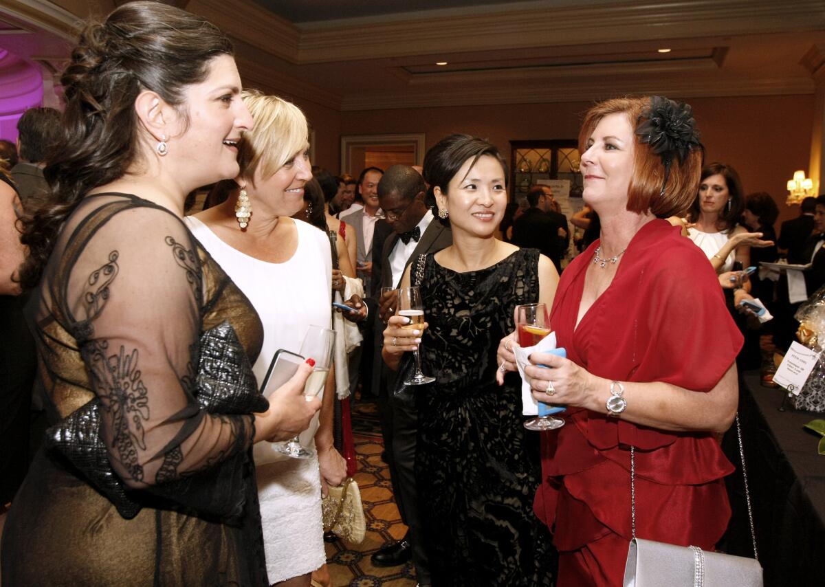Soo Choi, second from right, and Dale Storz, right, chat with friends at the La Cañada Flintridge Educational Foundation 23rd Annual Spring Gala at the Langham Huntington in Pasadena on Saturday, March 15, 2014.