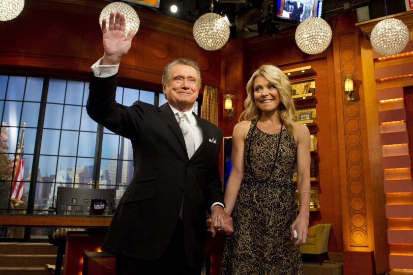 FILE - In this Friday, Nov. 18, 2011, file photo, Regis Philbin and Kelly Ripa appear on Regis' farewell episode of "Live! with Regis and Kelly", in New York. Philbin, the genial host who shared his life with television viewers over morning coffee for decades and helped himself and some fans strike it rich with the game show “Who Wants to Be a Millionaire,” has died on Friday, July 24, 2020. (AP Photo/Charles Sykes, File)