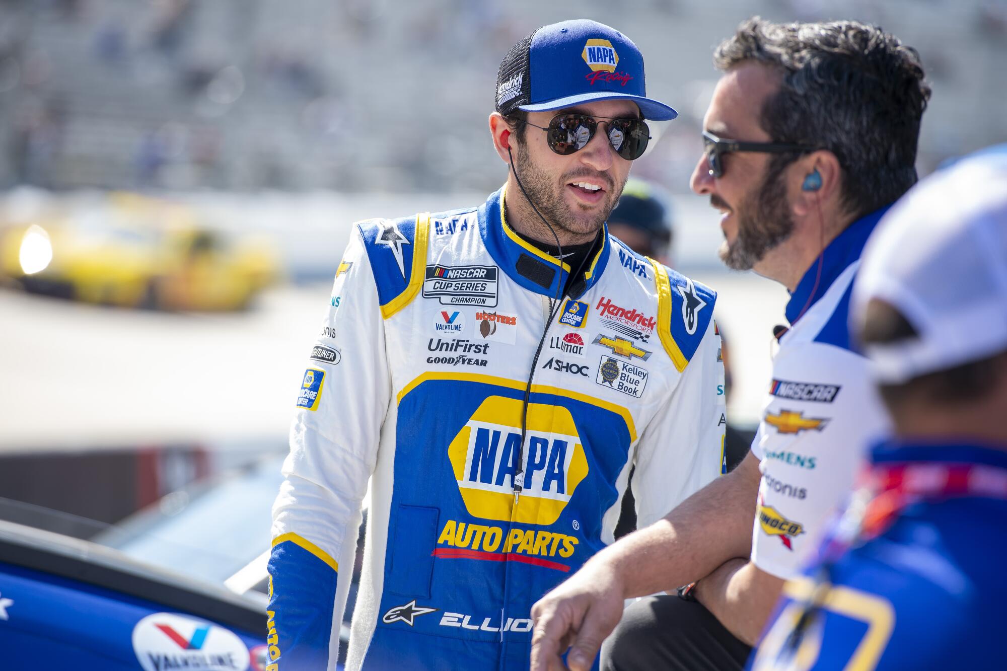 Chase Elliott talks with a team member during a NASCAR Cup Series practice at Dover Motor Speedway.