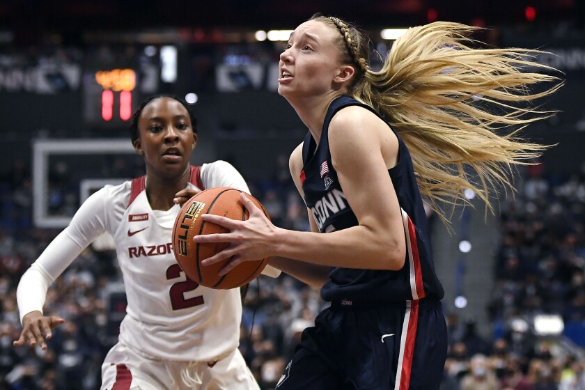 Connecticut's Paige Bueckers drives past Arkansas' Samara Spencer (2) in the second half of an NCAA college basketball game, Sunday, Nov. 14, 2021, in Hartford, Conn. (AP Photo/Jessica Hill)