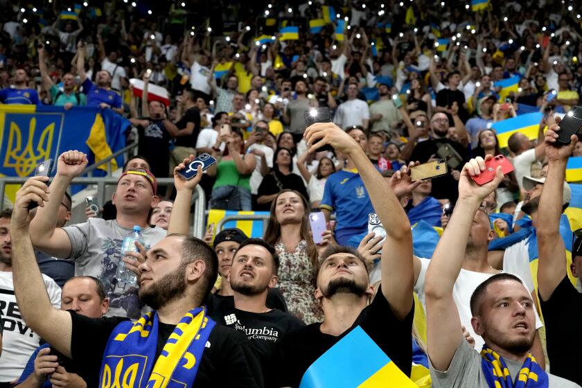 Fans of Ukraine hold smartphones with torches switched on during the Euro 2024 group C qualifying soccer match between Ukraine and England in Wroclaw, Poland, Saturday, Sept. 9, 2023. (AP Photo/Czarek Sokolowski)