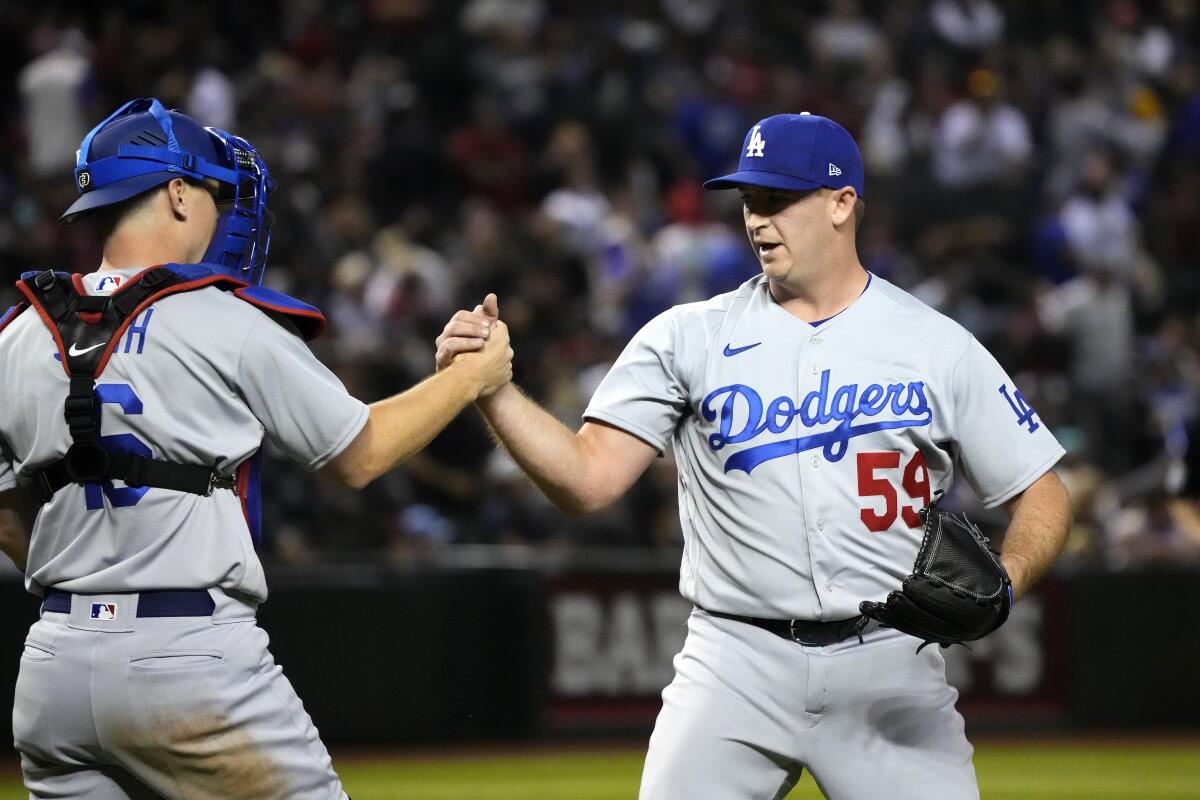 Dodgers' Evan Phillips, right, celebrates with Will Smith after a win against the Arizona Diamondbacks on April 6.