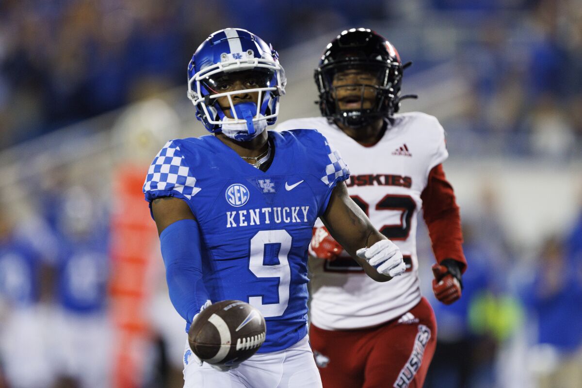 Kentucky wide receiver Tayvion Robinson (9) runs the ball into the end zone for a touchdown while being chased by Northern Illinois cornerback Cyrus McGarrell (22) during the second half of an NCAA college football game in Lexington, Ky., Saturday, Sept. 24, 2022. (AP Photo/Michael Clubb)