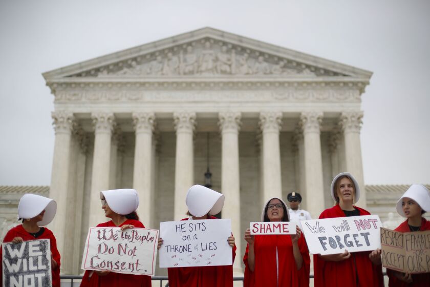 Activists protest in front of the Supreme Court in Washington, Tuesday, Oct. 9, 2018. A Supreme Court with a new conservative majority takes the bench as Brett Kavanaugh, narrowly confirmed after a bitter Senate battle, joins his new colleagues to hear his first arguments as a justice. (AP Photo/Pablo Martinez Monsivais)