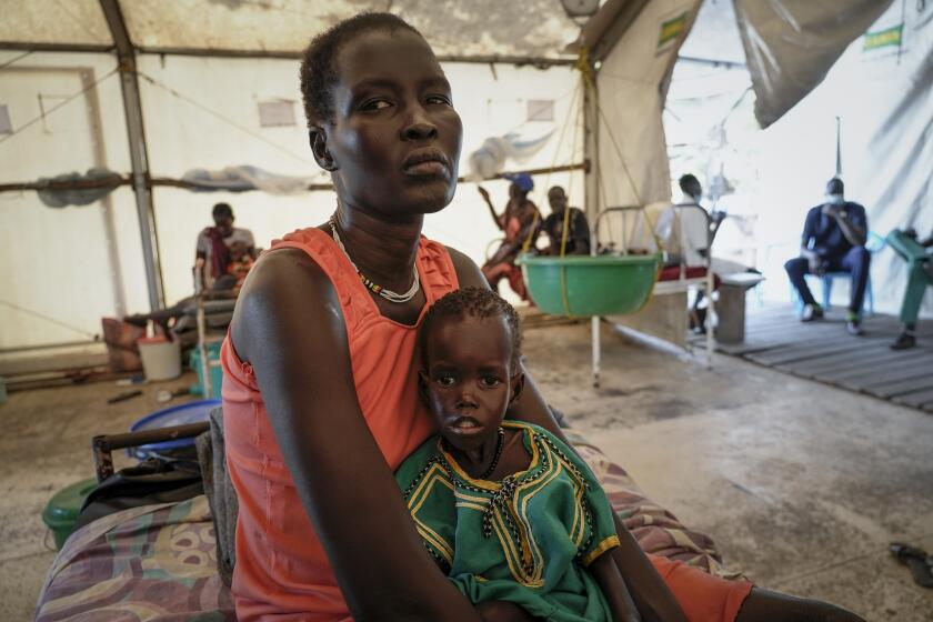 Nyayiar Kuol holds her severely malnourished 1-year-old daughter Chuoder Wal in a hospital run by Medicines Sans Frontieres (Doctors Without Borders) in Old Fangak in Jonglei state, South Sudan Tuesday, Dec. 28, 2021. Aid groups say more people than ever in the country will face hunger this year, because of the worst floods in 60 years as well as conflict and the sluggish implementation of the peace agreement that has denied much of the country basic services. (AP Photo/Sam Mednick)