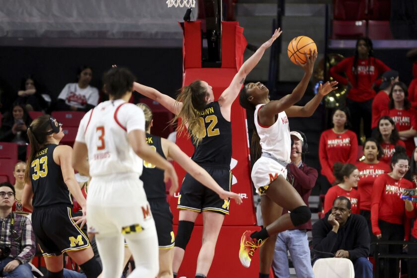 Maryland guard Diamond Miller, right, attempts to shoot during the first half of an NCAA college basketball game against Michigan, Thursday, Jan. 26, 2023, in College Park, Md. (AP Photo/Julia Nikhinson)