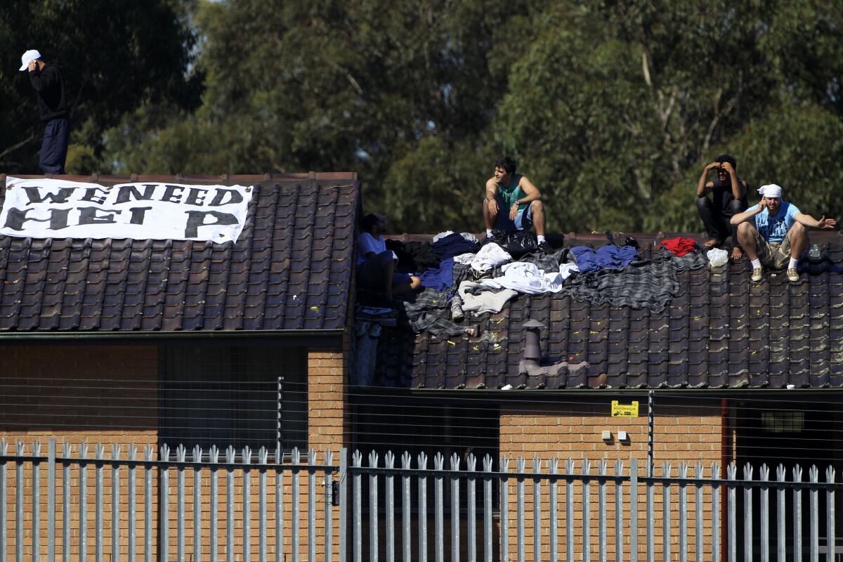 Men gather on a rooftop at the Villawood Detention Center in Sydney, Australia, in 2011.