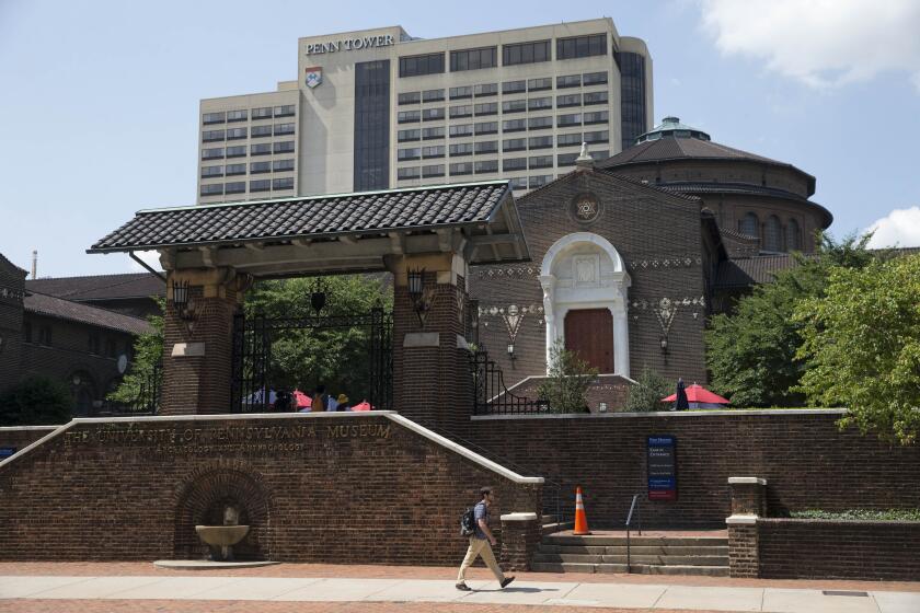 FILE - A man walks past the The Penn Museum, part of the University of Pennsylvania, Tuesday, Aug. 5, 2014, in Philadelphia. As part of a growing effort among museums to reevaluate the curation of human remains, the Ivy League school laid some of the remains to rest last week – specifically those identified as belonging to 19 Black Philadelphians – and officials are holding a memorial service for them on Saturday, Feb. 2, 2024. (AP Photo/Matt Rourke, File)