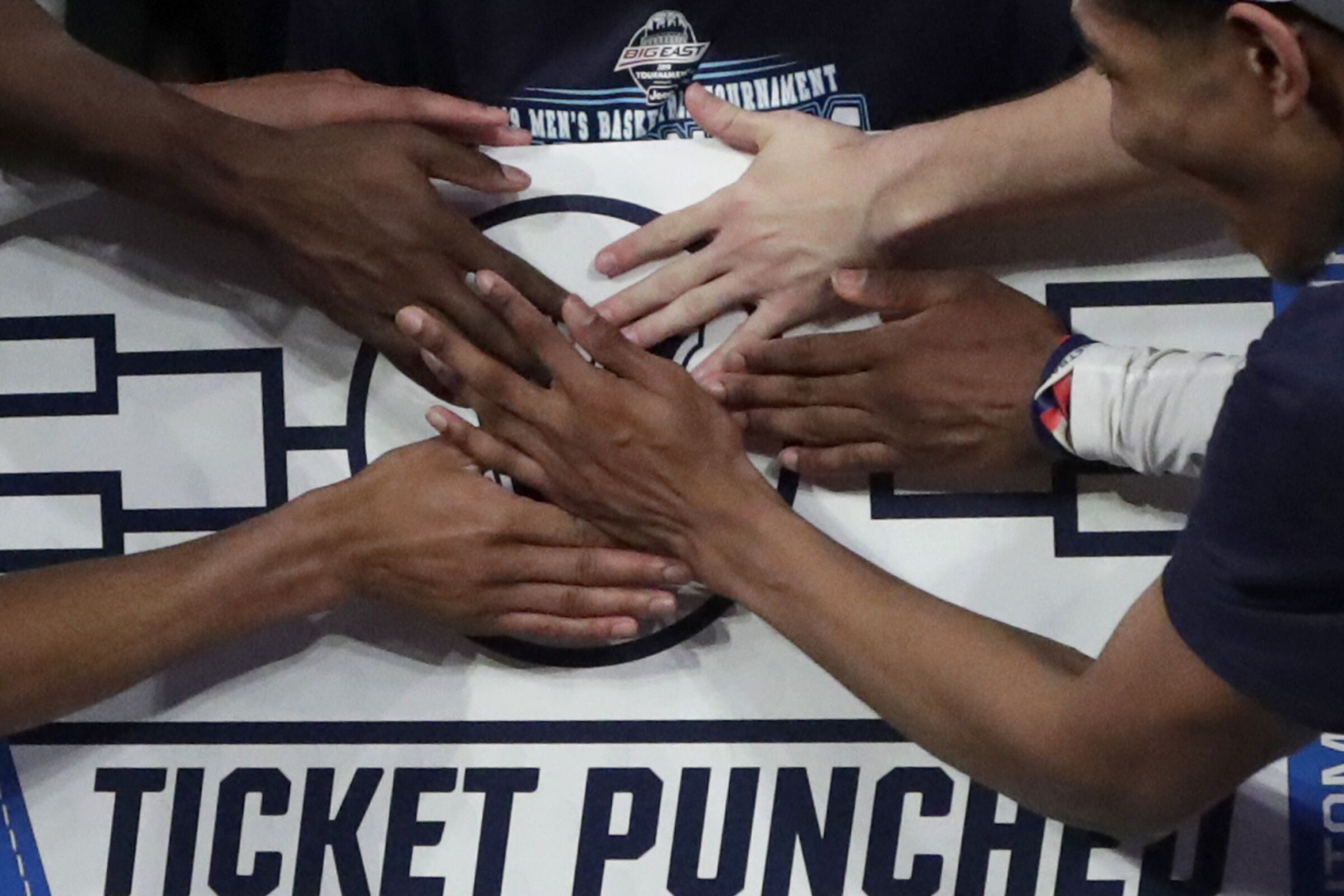 Villanova players stick a logo of their team on a bracket board after defeating Seton Hall in 2019.