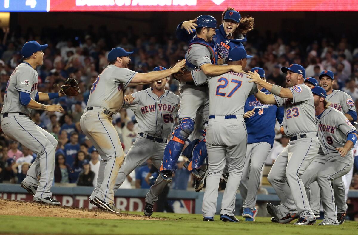Mets pitcher Jacob deGrom jumps into the arms of catcher Travis d'Arnaud and closer Jeurys Familia (27) after beating the Dodgers, 3-2, to win the National League division series.