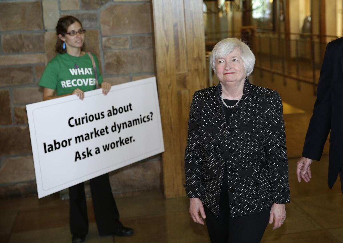 Federal Reserve Chairwoman Janet L. Yellen passes a protestor on her way to a dinner at the Jackson Hole Economic Policy Symposium in Wyoming on Thursday.