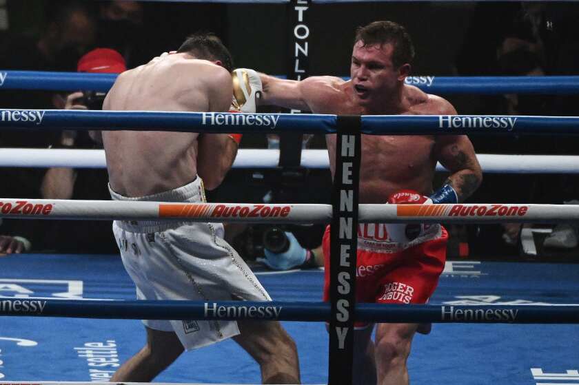 Canelo Alvarez punches Callum Smith during their title fight.