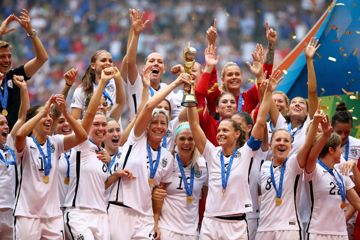 The United States women's team hoists the World Cup Trophy in celebration.
