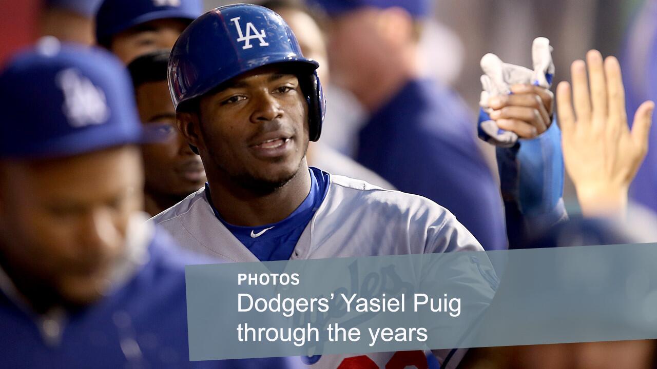 Dodgers center fielder Yasiel Puig is congratulated by teammates after scoring against the Angels during a game in Anaheim last season.