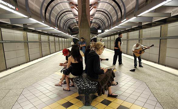 A man with his guitar serenades passengers waiting for a subway train at the Hollywood-Highland station in Los Angeles.
