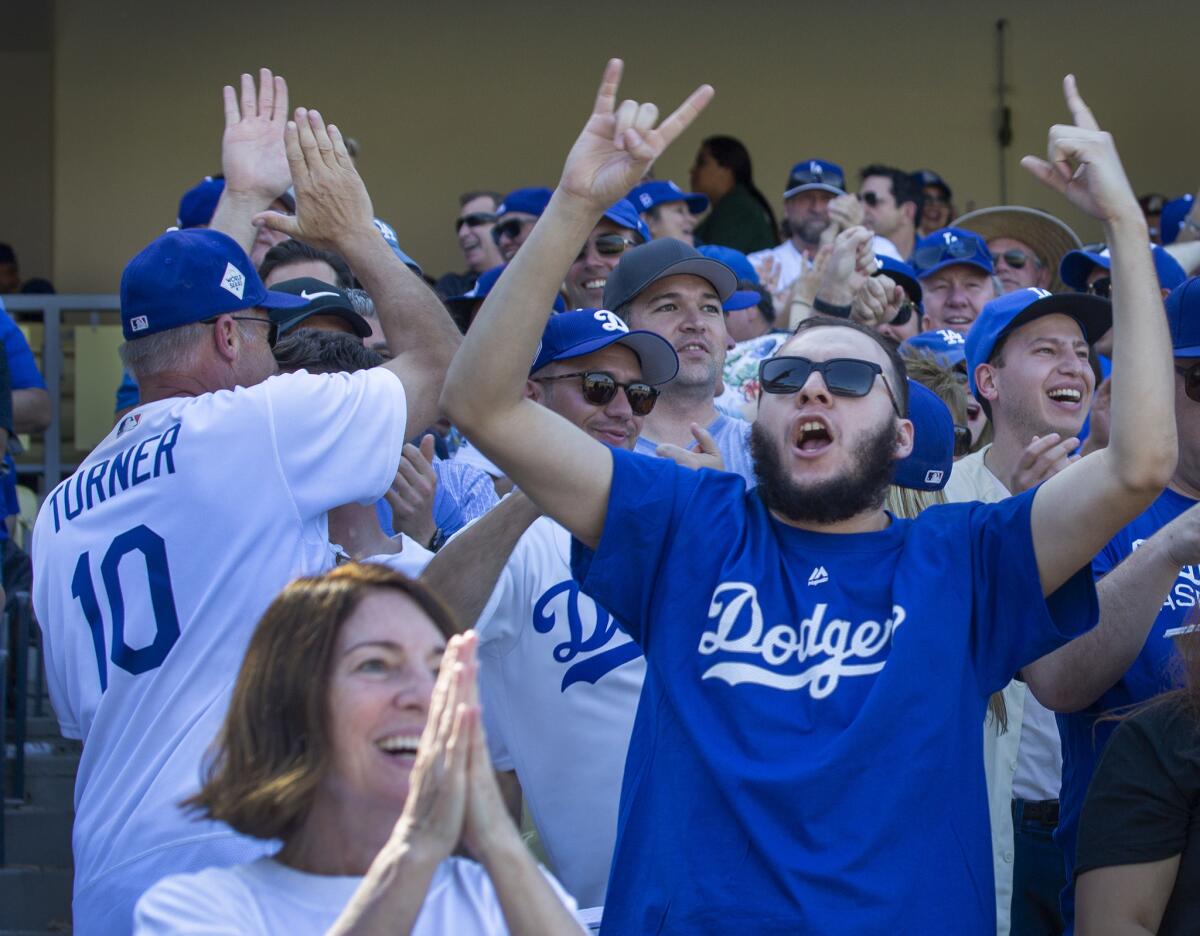 Dodgers fans celebrate Cody Bellinger's seventh inning home run on opening day at Dodger Stadium.