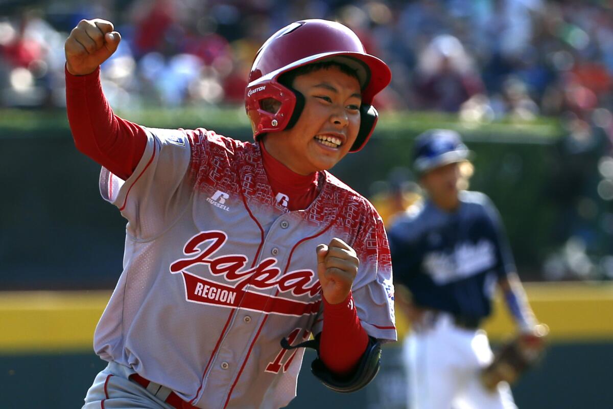 Japan's Masafuji Nishijima pumps his fist as he rounds third base after hitting a three-run home run in the Little League World Series Championship.