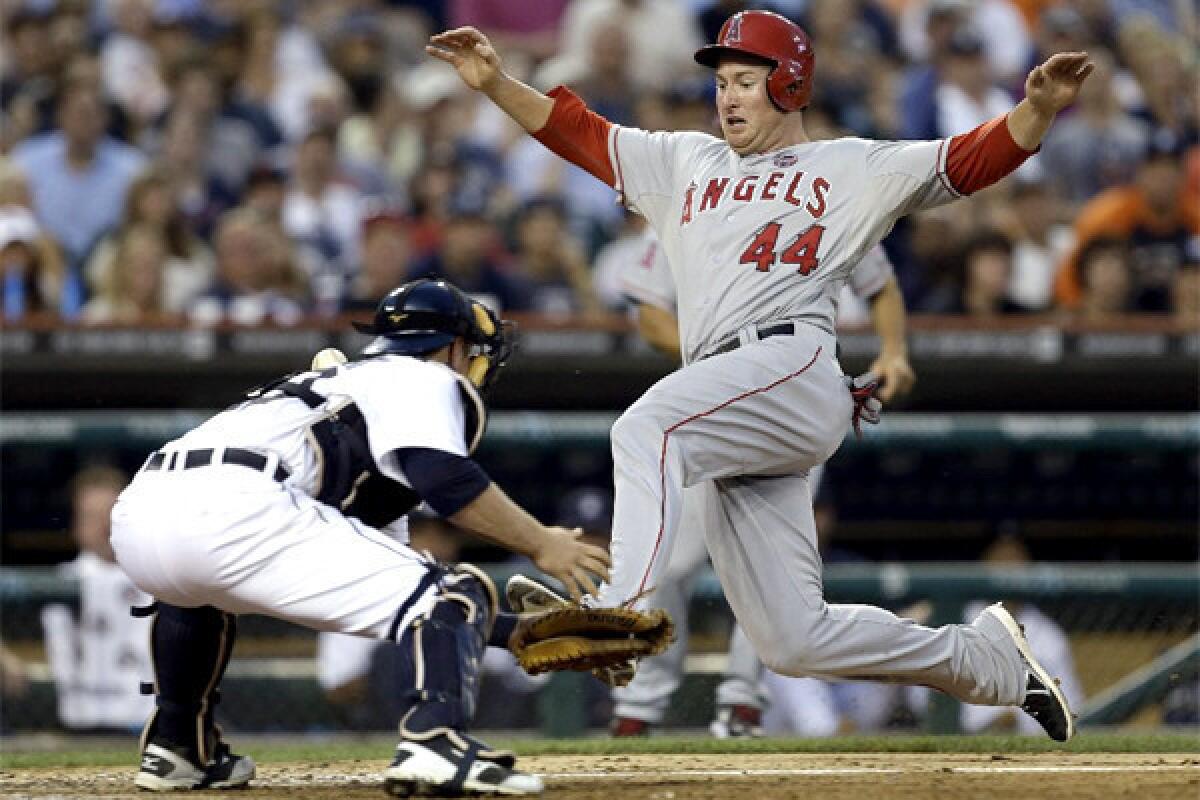 Mark Trumbo scores on a Josh Hamilton single as Detroit's Bryan Holaday is unable to wrangle the throw to the plate during the Angels' victory over Detroit, 14-8.