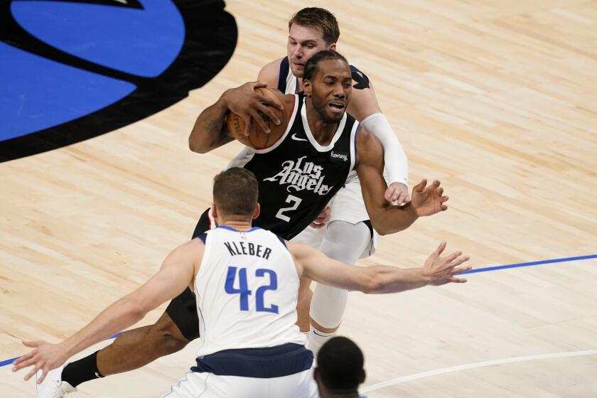 Dallas Mavericks' Maxi Kleber (42) and Luka Doncic, rear, defend as Los Angeles Clippers forward Kawhi Leonard (2) drives to the basket in the first half in Game 4 of an NBA basketball first-round playoff series in Dallas, Sunday, May 30, 2021. (AP Photo/Tony Gutierrez)