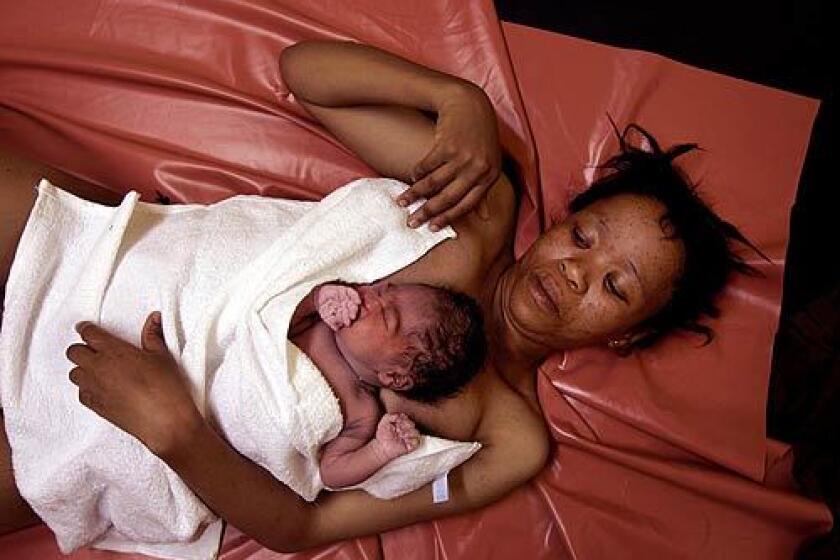 Mother and daughter: Lizketseng Lesaoana, 25, half an hour after delivering a baby girl at Queen Elizabeth II Hospital in Maseru, Lesotho. They lie on a plastic sheet that is cleaned with a damp cloth between births.