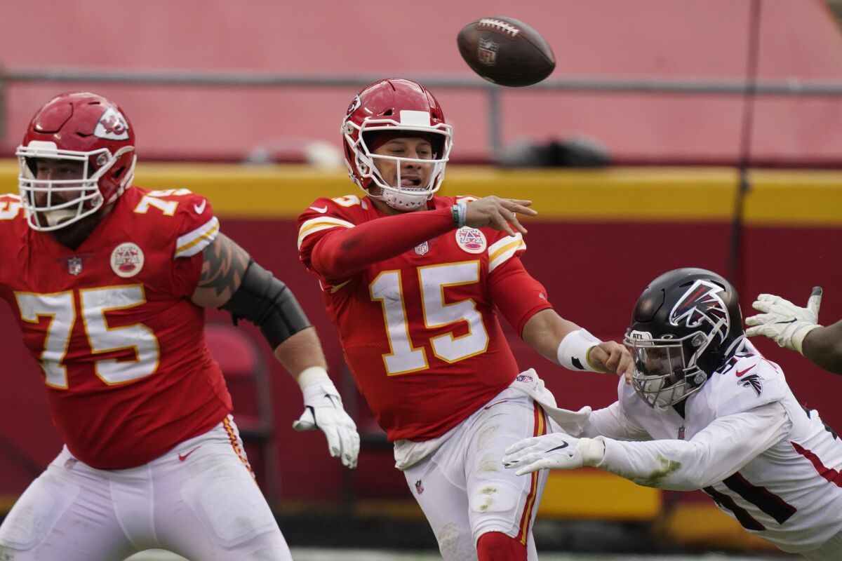 Kansas City Chiefs quarterback Patrick Mahomes throws a pass while being chased down by Atlanta Falcons Jacob Tuioti-Mariner during the second half of an NFL football game, Sunday, Dec. 27, 2020, in Kansas City. (AP Photo/Charlie Riedel)
