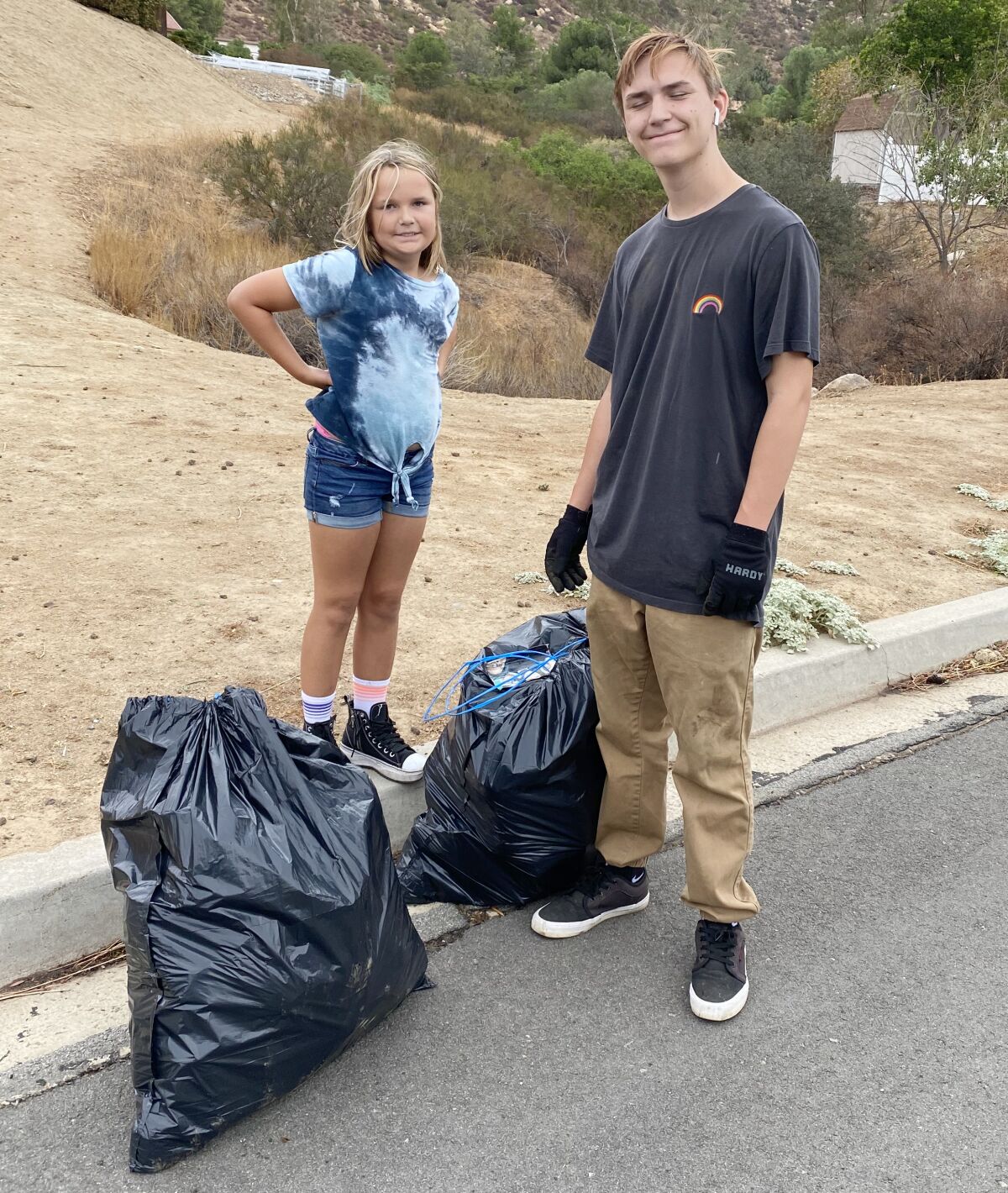 Harlie Fields, left, and Eli Lieb bagged trash in the Bellemore Drive neighborhood of San Diego Country Estates.