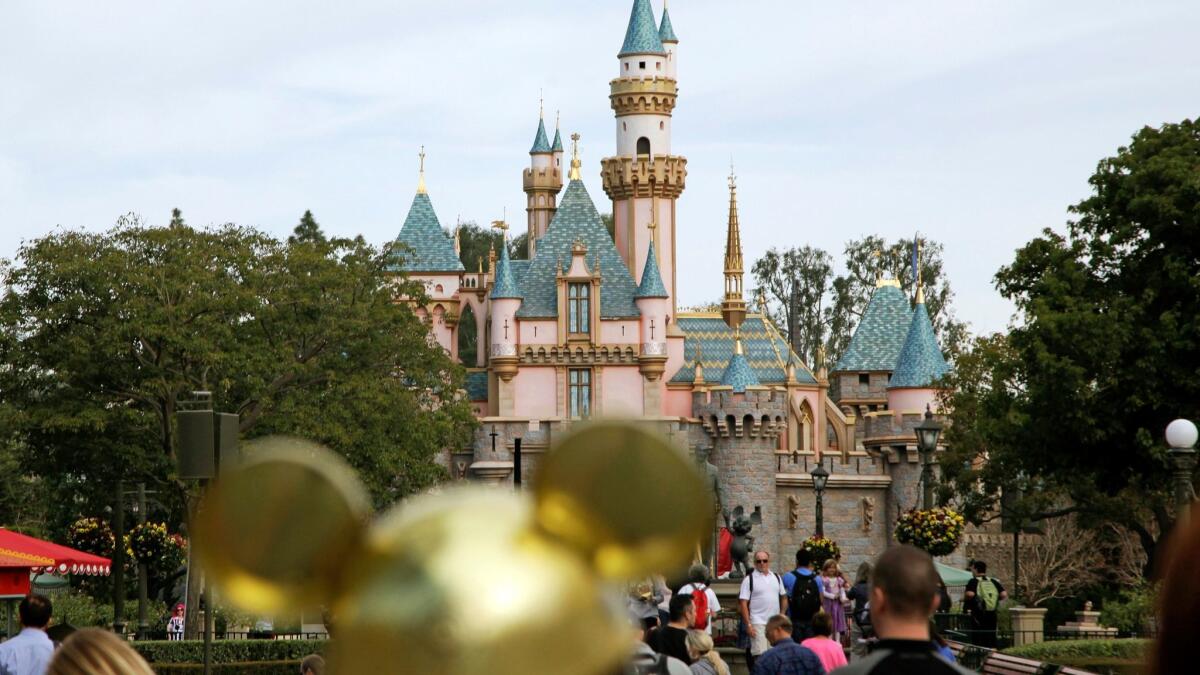 Visitors walk toward Sleeping Beauty's Castle at Disneyland in Anaheim.