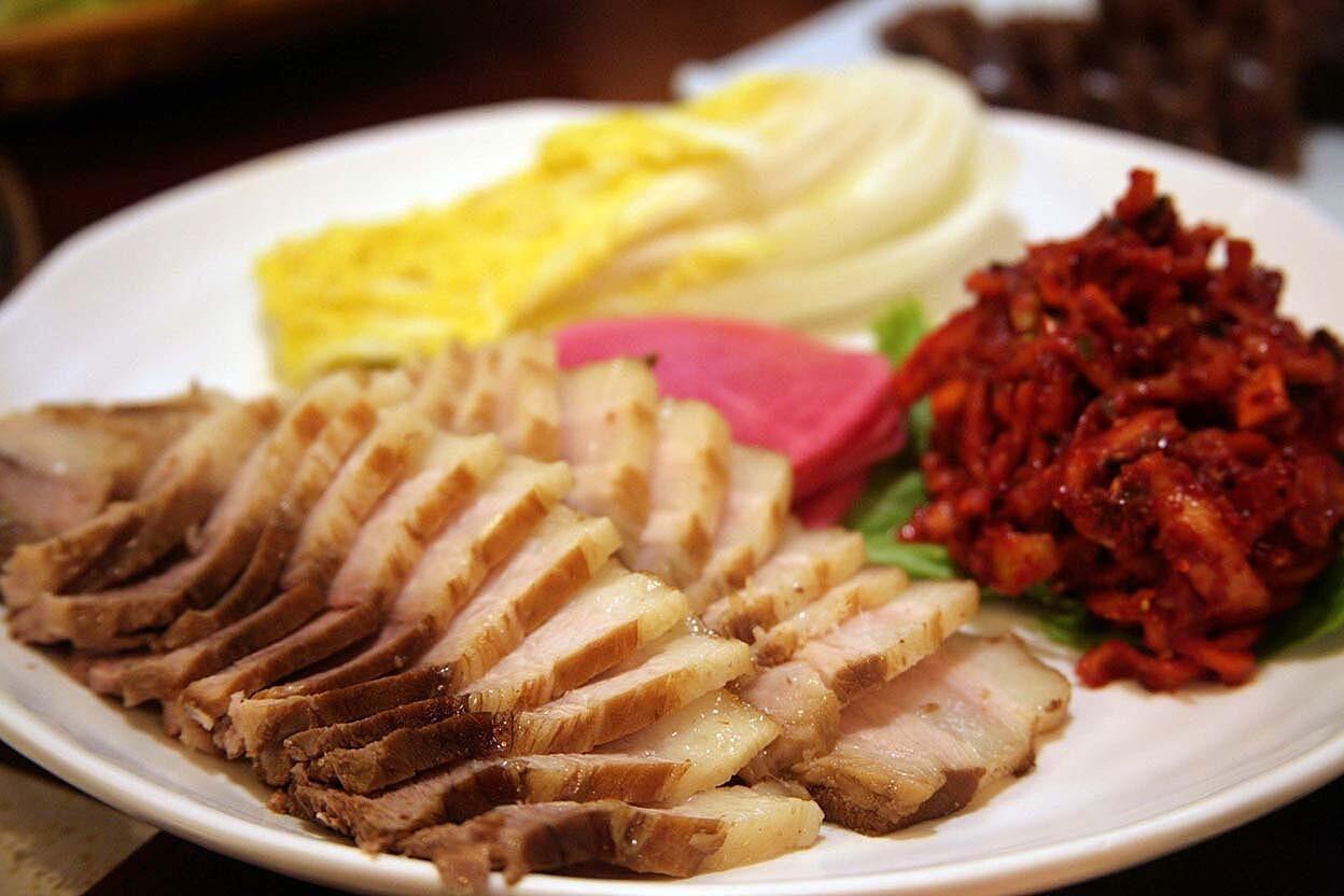 Tender slices of pork come with napa cabbage leaves, jutgal (kimchi filling) and pickled radishes. It's like a deconstructed kimchi dish with pork.