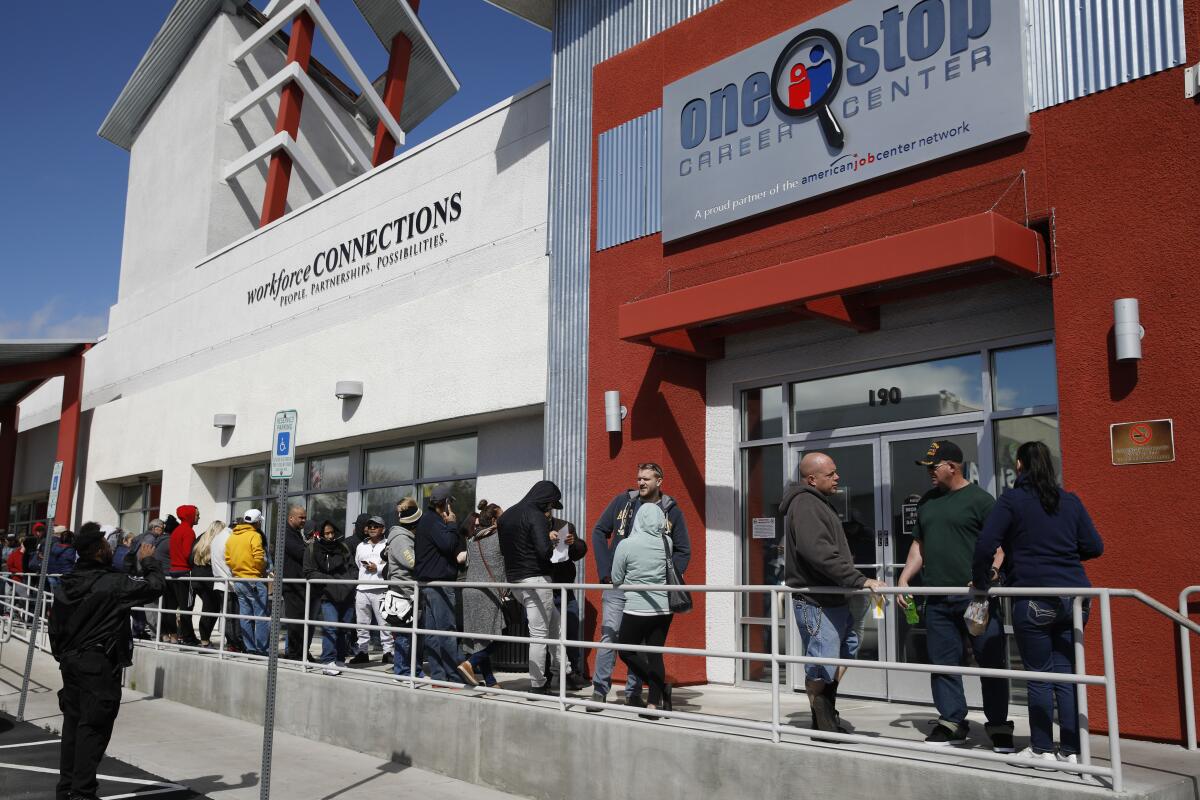 People in Las Vegas stand in line for help with unemployment benefits.