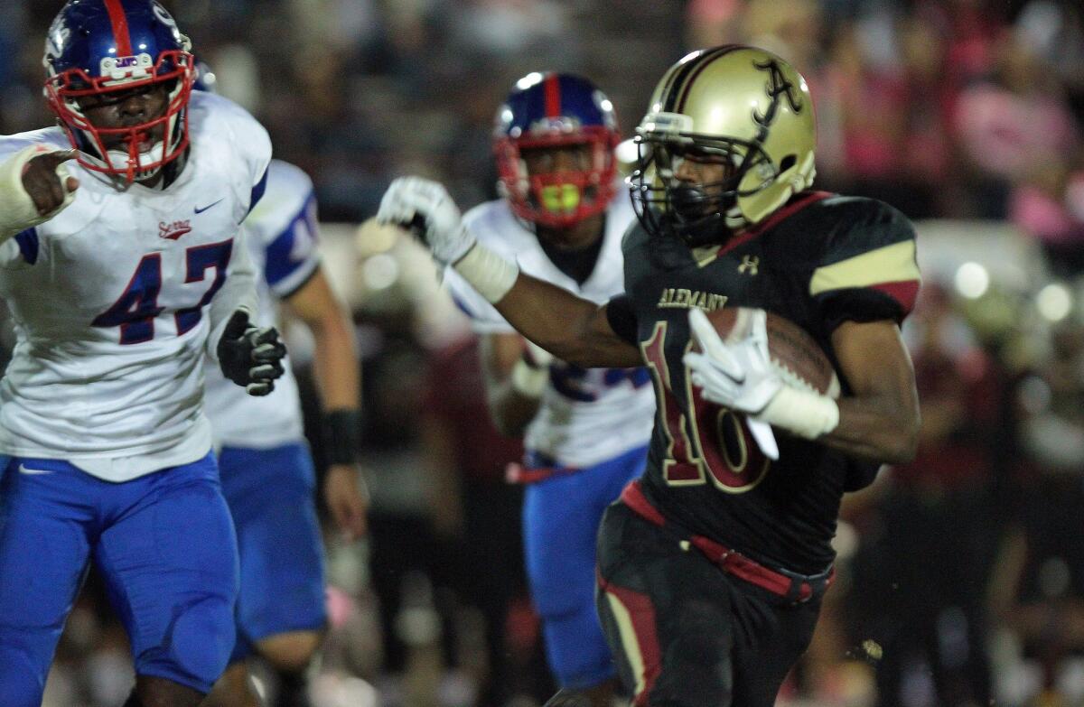 Alemany High School running back Dominic Davis is pursued by Serra defensive lineman Oluwole Betiku back in October.