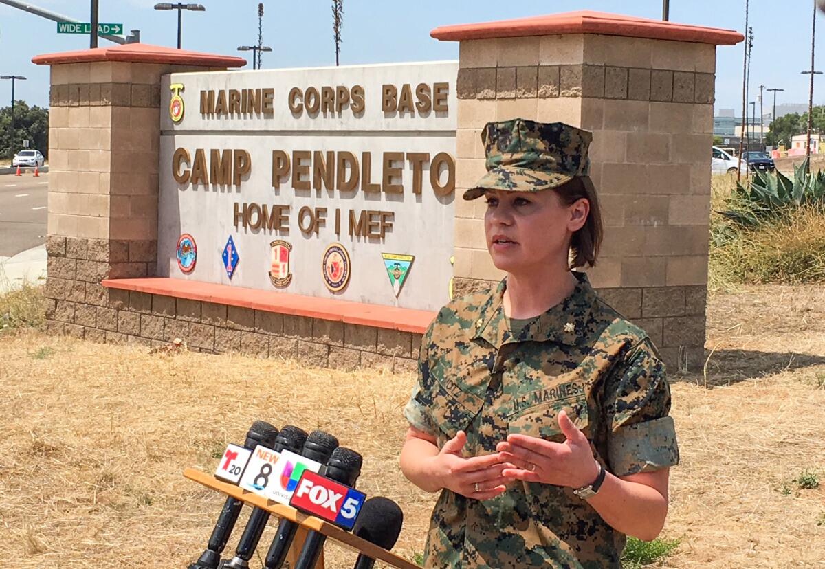 Major Kendra Motz speaks to the media about the 16 Marines arrested on human smuggling and drug-related allegations outside the main gate to Camp Pendleton on July 25, 2019. Photo by Charlie Neuman