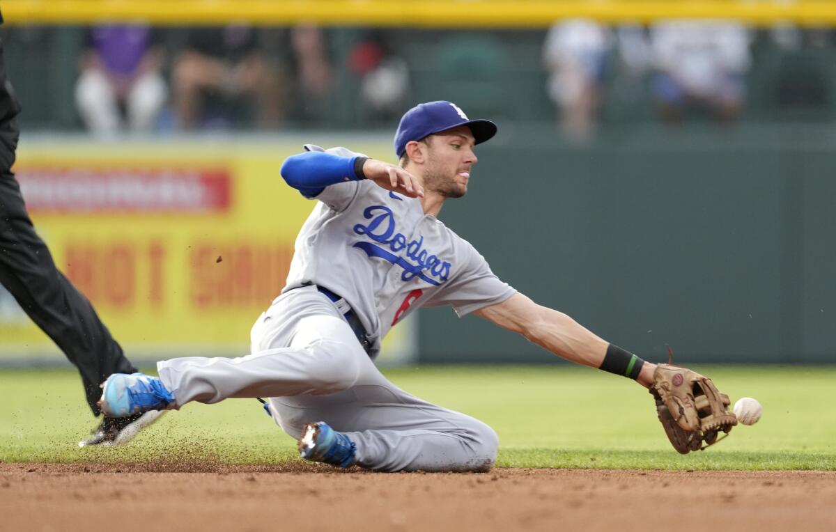 Dodgers shortstop Trea Turner dives for a ground ball off the bat of Colorado Rockies' Connor Joe.