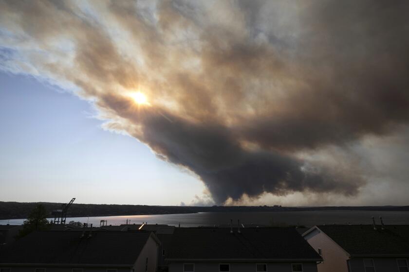 Thick plumes of heavy smoke fill the Halifax sky as an out-of-control fire in a suburban community quickly spread, engulfing multiple homes and forcing the evacuation of local residents, in Halifax, Nova Scotia, on Sunday May 28, 2023. (Kelly Clark/The Canadian Press via AP)