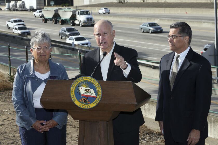 Calif., Governor Jerry Brown, center, blasts a Trump administration plan to freeze vehicle emissions standards, saying it threatens public health and the environment, Friday, Oct. 26, 2018, in Sacramento, Calif. Brown was joined by California Air Resources Board Chairperson Mary Nichols, and Attorney General Xavier Becerra. (AP Photo/Rich Pedroncelli)