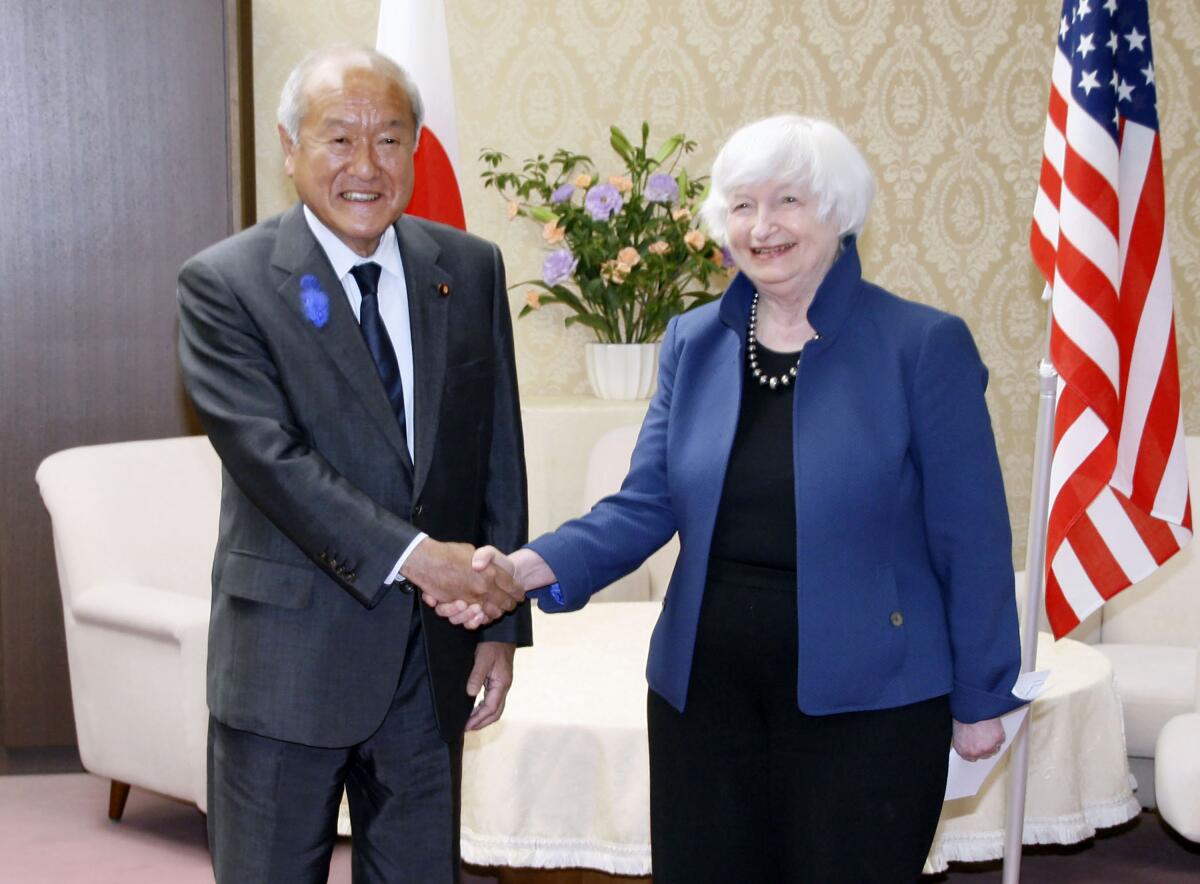 U.S. Treasury Secretary Janet Yellen, right, and Japan's Finance Minister Shunichi Suzuki shake hands during their meeting at the finance ministry in Tokyo, Tuesday, July 12, 2022. With thousands of sanctions already imposed on Russia to flatten its economy, the U.S. and its allies are working on new measures to starve the Russian war machine while also stopping the price of oil and gasoline from soaring to levels that could crush the global economy. (Kyodo News via AP)