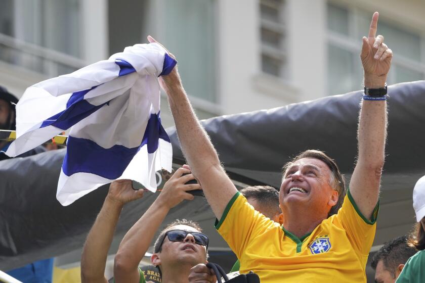El expresidente brasileño Jair Bolsonaro alza los brazos ante sus simpatizantes durante un mitin el domingo 25 de febrero de 2024, en Sao Paulo. (AP Foto/André Penner)