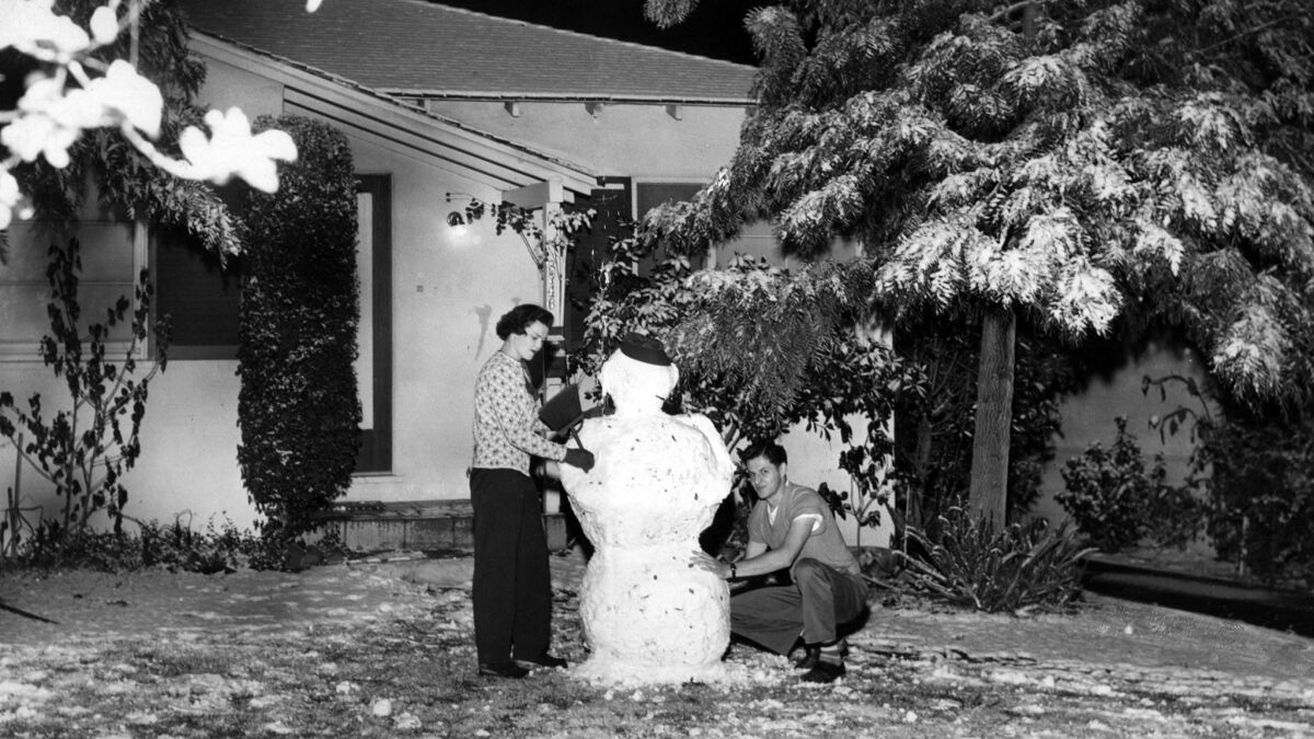 Jan. 9, 1949: Mrs. and Mr. Harvey Tibbals put the finishing touches on a snowman outside their La Crescenta Avenue home in Montrose.