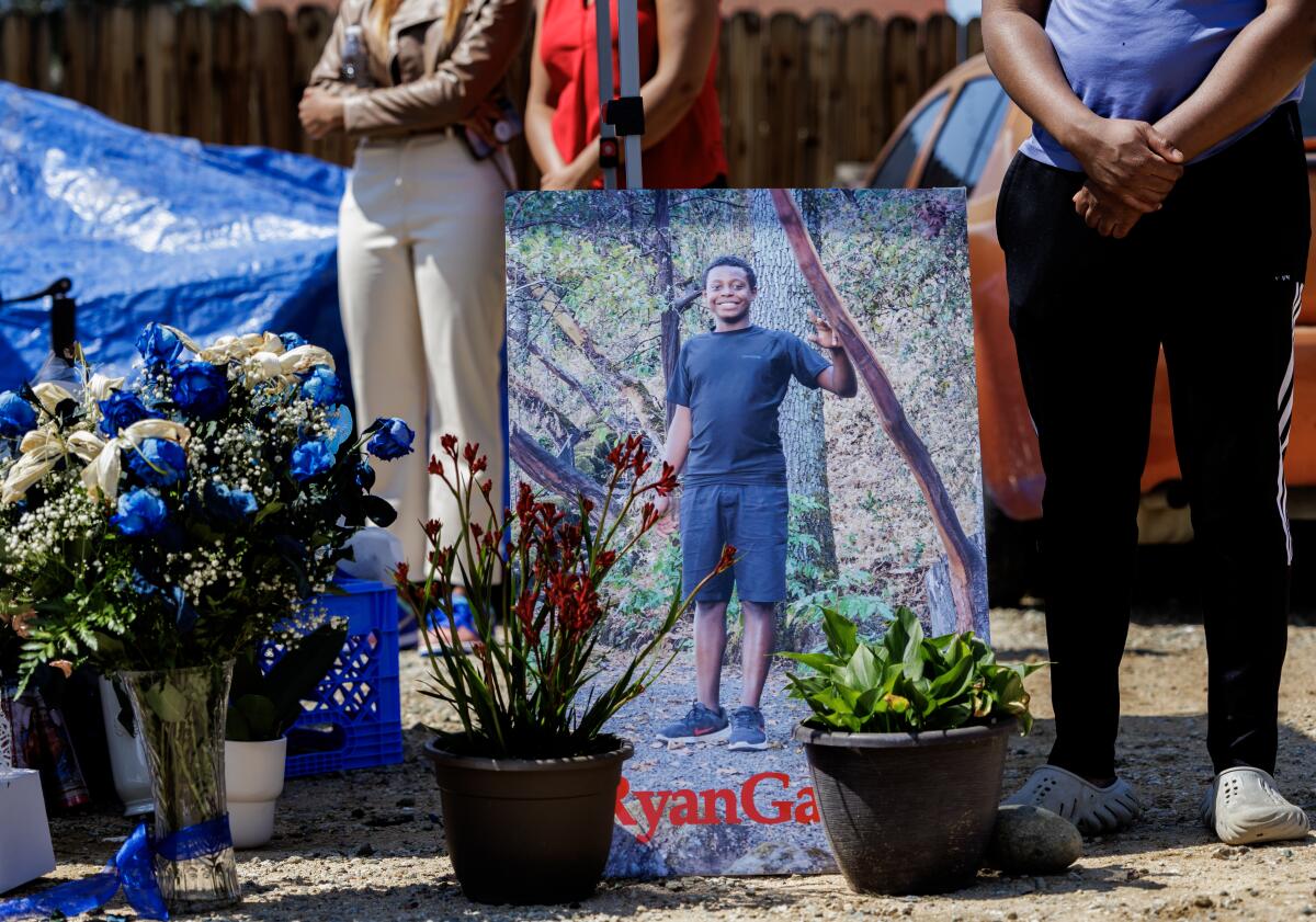 A poster-size photo of slain Ryan Gainer stands at the spot where he was killed